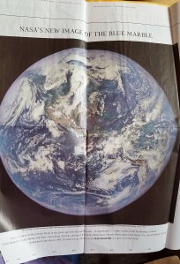 Newspaper clipping of a recent photo of the earth from a satellite launched many years ago.